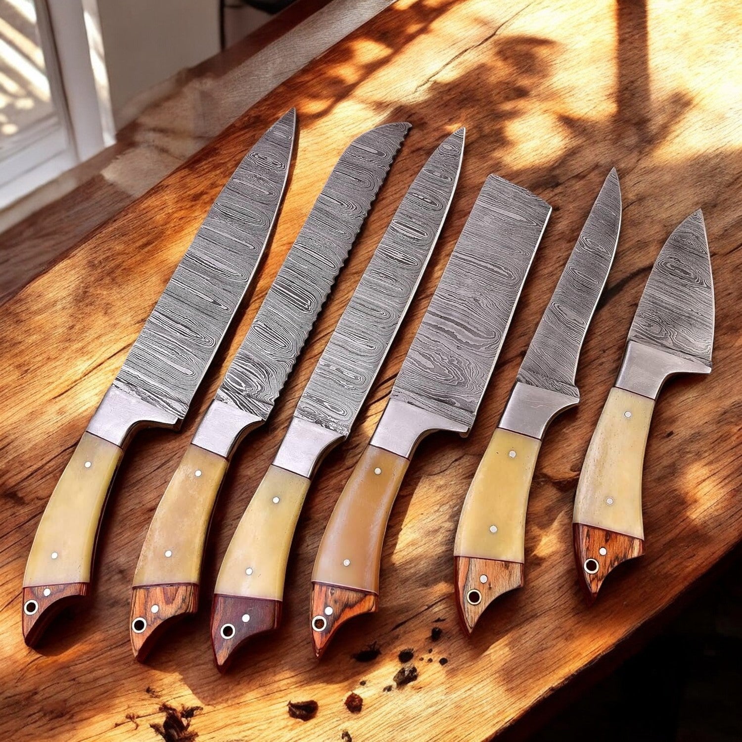 Custom Damascus kitchen knives set with bone and wood handles.
