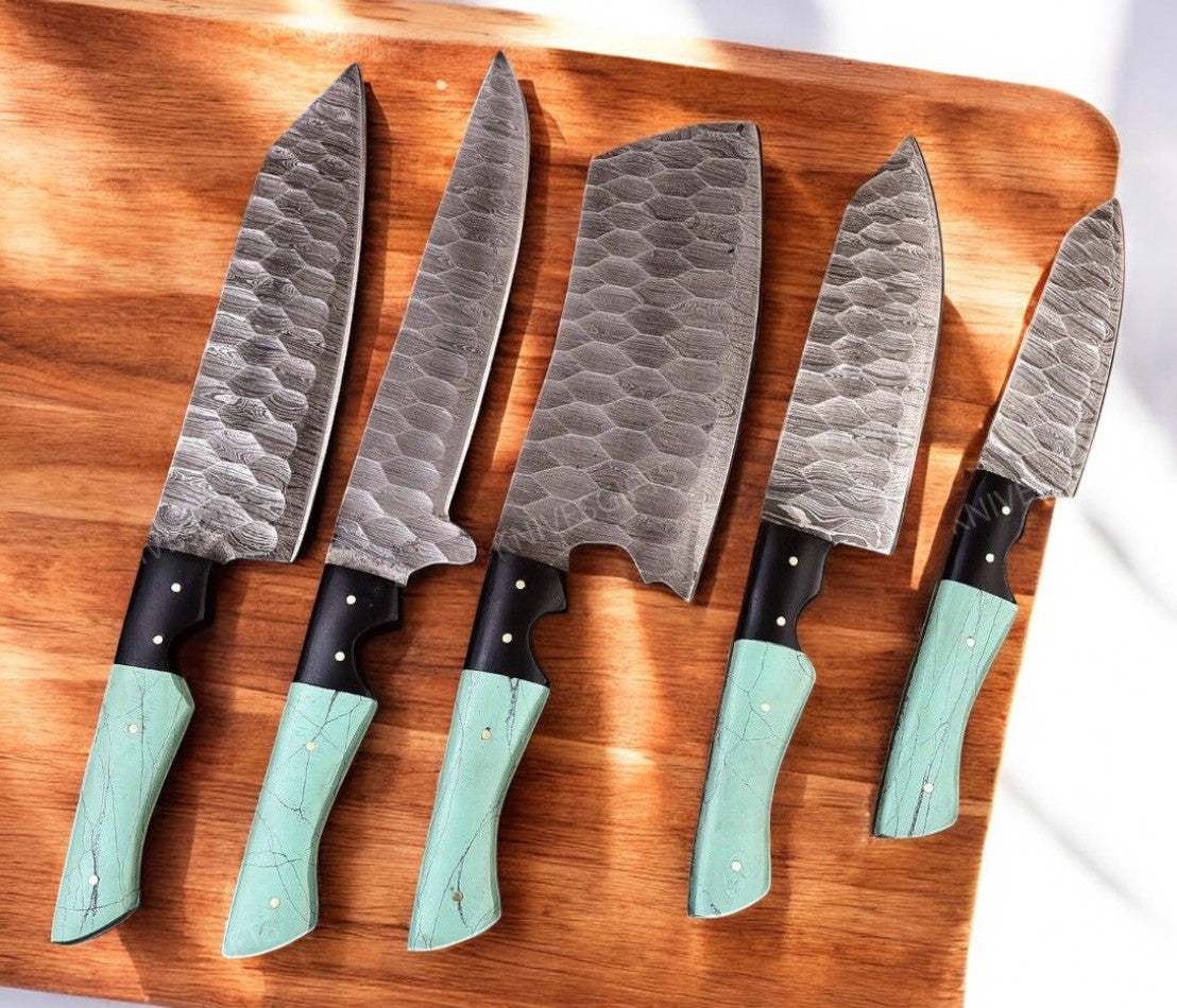 Close-up of Damascus kitchen knife set showcasing intricate blade patterns.
