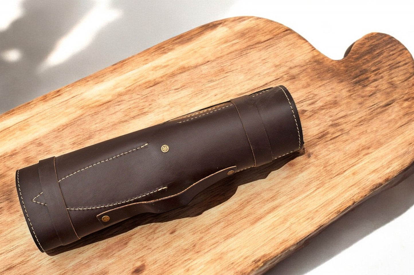 Leather roll neatly displaying a custom handmade Damascus knife set
