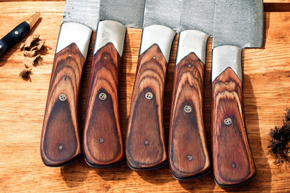 Exotic wood handles of custom kitchen knives in detail.
