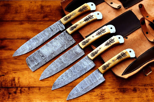 Full custom Damascus kitchen knife set displayed with a leather roll.
