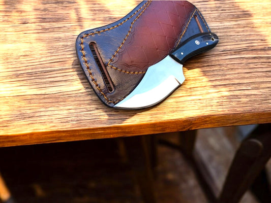 Handcrafted cowboy fixed blade knife with resin handle on rustic wood background.
