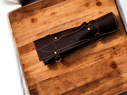 Set of handmade kitchen knives stored in a leather roll.
