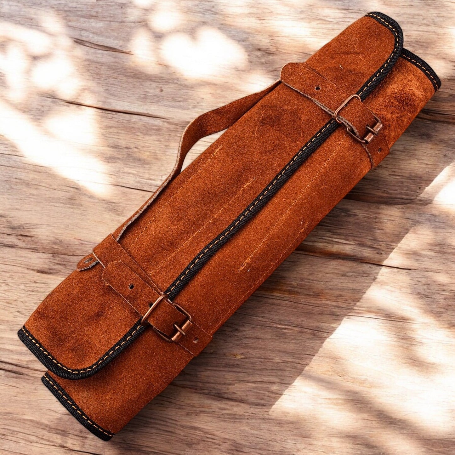 Set of handmade chef knives arranged on a leather roll.
