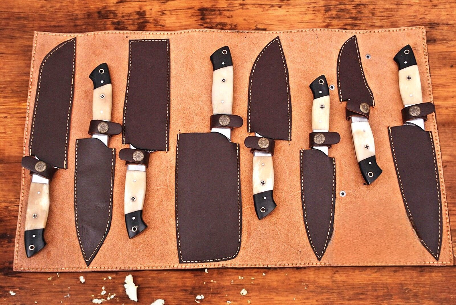 Full view of a handmade Damascus knife set in leather roll.
