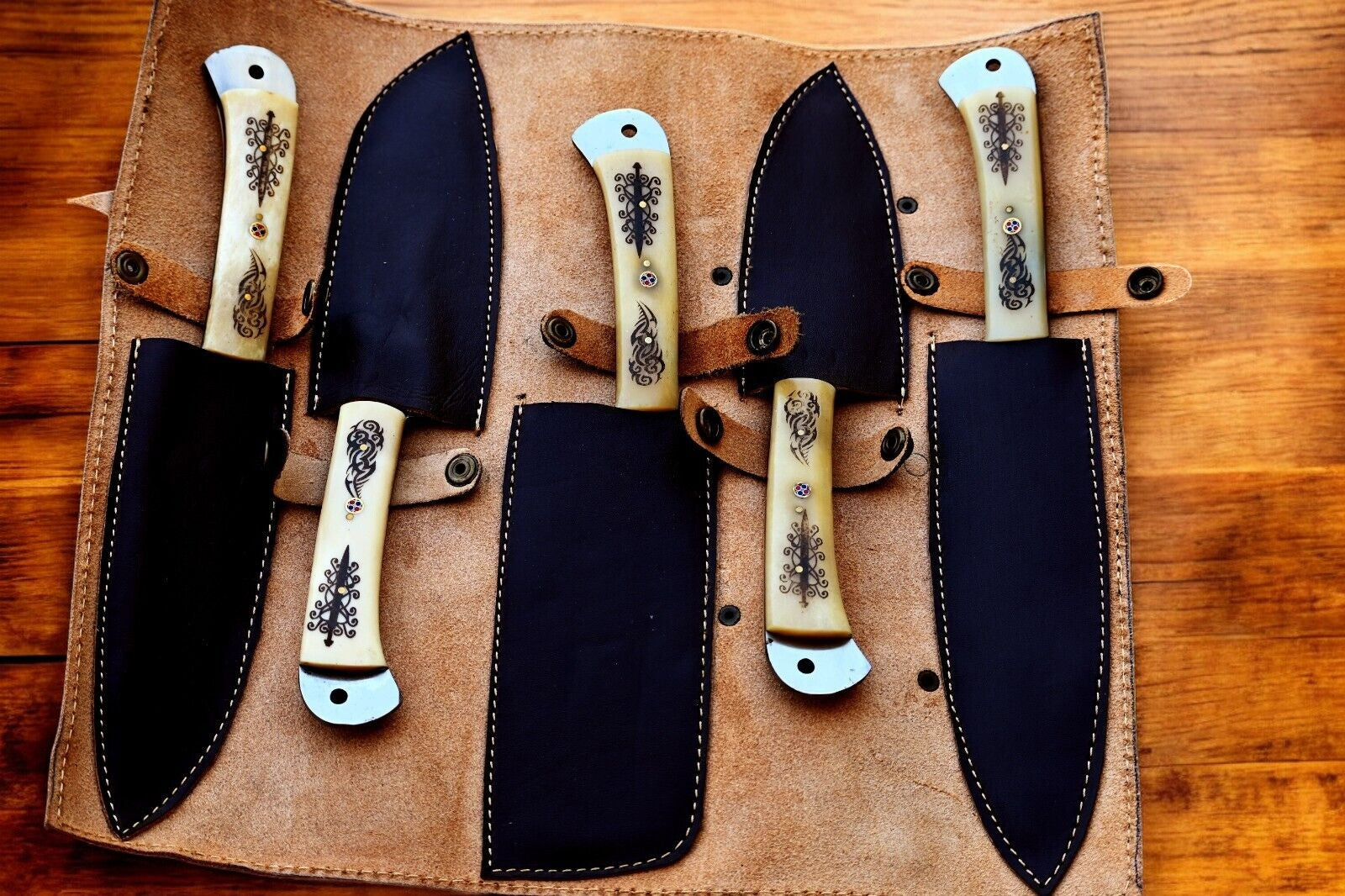 Handmade kitchen knives being placed in the leather roll.
